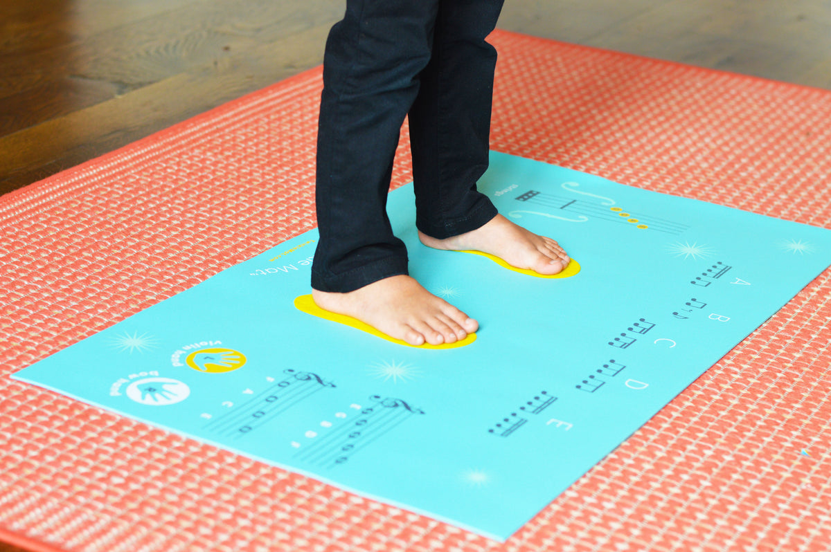 Violin student standing on Twinkle Mat violin practice mat. 